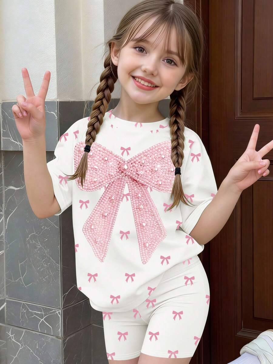 一套女童T恤短裤两件套,饰有大蝴蝶结和全身蝴蝶结印花,可爱甜美的短袖上衣搭配蝴蝶结短裤,适合夏季外出、上学、度假等场合。 - 彩色 - 查看 1
