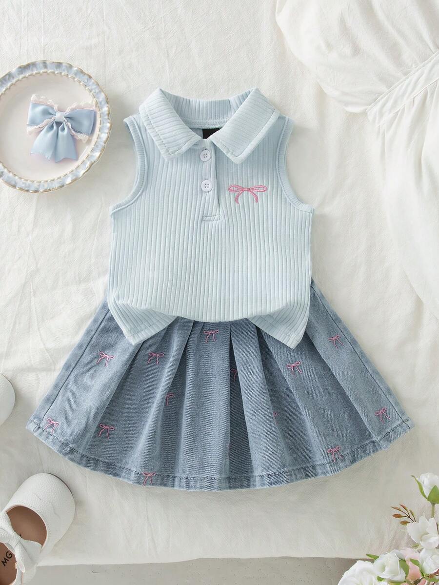 Vintaside Kids 女嬰短袖無袖套裝，象牙白上衣 + 淺藍色牛仔裙。上衣為無袖彈性 Polo 領針織設計，胸前有粉色蝴蝶結刺繡。裙子為淺色水洗牛仔短裙，飾有白色刺繡蝴蝶結。整體風格甜美可愛，適合夏季穿著、日常出遊、幼兒園、派對和家庭休閒場合。