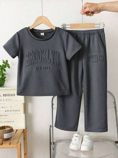 SHEIN Bộ 2 món cho bé trai gồm áo thun cổ tròn tay ngắn in chữ có túi hộp và quần dài màu xám, trang phục thể thao thường ngày phù hợp cho mùa xuân, hè, thu, đa năng cho kỳ nghỉ, đi học, dự tiệc.