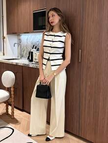 Pariaura Áo thun dệt kim ôm dáng trẻ trung, tối giản kiểu Pháp, màu đen trắng kẻ sọc, cổ tròn, vạt áo bất đối xứng với khóa kim loại và đường xẻ phía trước. Chất liệu dệt kim đa năng, phù hợp cho mùa xuân, hè, thu, mặc hàng ngày, đi làm và đi nghỉ mát. - Đen và trắng - Xem 3
