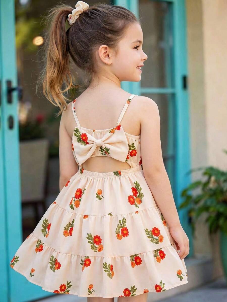 SHEIN Vintaside Kids 这款杏色热带花卉图案吊带连衣裙，后腰处饰有蝴蝶结，裙摆呈喇叭形，是夏季时尚休闲海滩度假的理想之选。