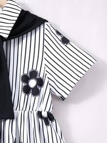 SHEIN 这款少女条纹碎花连衣裙采用经典的黑白竖条纹面料，搭配俏皮的黑色碎花图案，尽显清新青春气息。衬衫领设计搭配前襟纽扣，方便穿脱，更添学院风范；收腰剪裁凸显身材曲线，宽松的A字长裙飘逸灵动，并附赠可拆卸黑色披肩，营造柔美气质。 - 黑色 - 查看 8