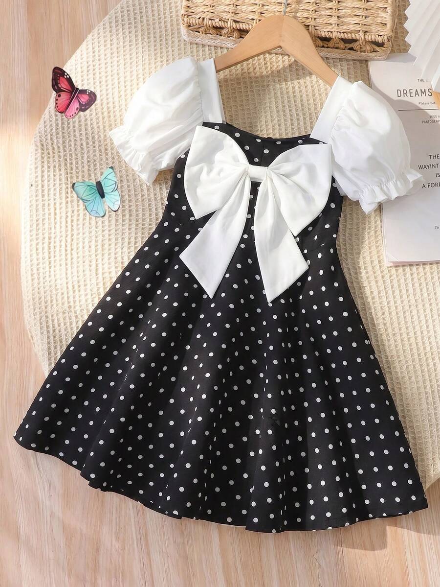 SHEIN Genkimix Kids 少女夏季A字洋裝，正面白色蝴蝶結裝飾，梭織面料白色泡泡袖短袖圓點圖案方領洋裝，白色仿珍珠鈕扣設計，適合少女，優雅迷人，休閒時尚，可愛日常、上學、出遊、度假、派對穿搭 - 黑與白 - 查看 1
