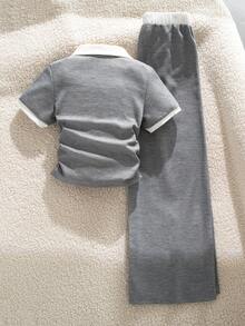 SHEIN 这款学院风女童撞色领两件套采用华夫格针织面料制成。上衣采用撞色白色彼得潘领设计，搭配V形门襟、白色滚边袖口和褶皱腰身，打造自然修身效果。配套的阔腿裤采用松紧腰带，并饰有精致的蝴蝶结。简约百搭，是上学和休闲外出的理想之选。 - 灰色 - 查看 2