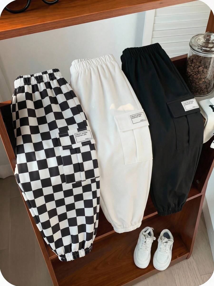 SHEIN 3件套男童休闲运动街头风可爱度假装，包括黑色装饰logo宽松白色慢跑裤、黑色慢跑裤和棋盘格慢跑裤，适合日常穿着、上学、外出、运动，春夏秋冬皆宜。