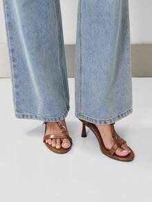 Nöista 極簡細帶涼鞋，亮面人造皮革打造，圓頭設計。 配有細緻平底帶、精緻T型構造與低調金屬環細節。 低雕塑感鞋跟與後跟帶設計，呈現優雅現代輪廓。 - 棕色 - 查看 4