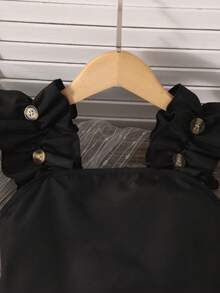 青少年女孩2件式優雅套裝，黑色方領荷葉邊肩帶無袖背心上衣 + 卡其色雙排扣百褶裙褲，甜美學院風夏季套裝，柔軟親膚透氣面料，輕盈舒適適合全天穿著，荷葉邊肩帶搭配金屬鈕扣細節增添少女奢華感，修身短版背心上衣展現身形曲線，高腰裙褲搭配雙排扣與百褶設計 - 彩色 - 查看 5