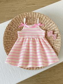 SHEIN Playful Pals Robe trapèze à bretelles spaghetti pour bébé fille. Cette robe présente un design à bretelles spaghetti, simple et élégant. La jupe trapèze met en valeur un style vif et mignon. La coupe ample de cette robe convient aux bébés de tous les types de corps. Elle est non seulement parfaite pour les vacances à la plage, les pique-niques en plein air et autres sorties d'été, mais aussi pour un port décontracté, permettant aux bébés de montrer leur charme unique tout en profitant d'un moment détendu et confortable. - Rose bonbon - Voir 3