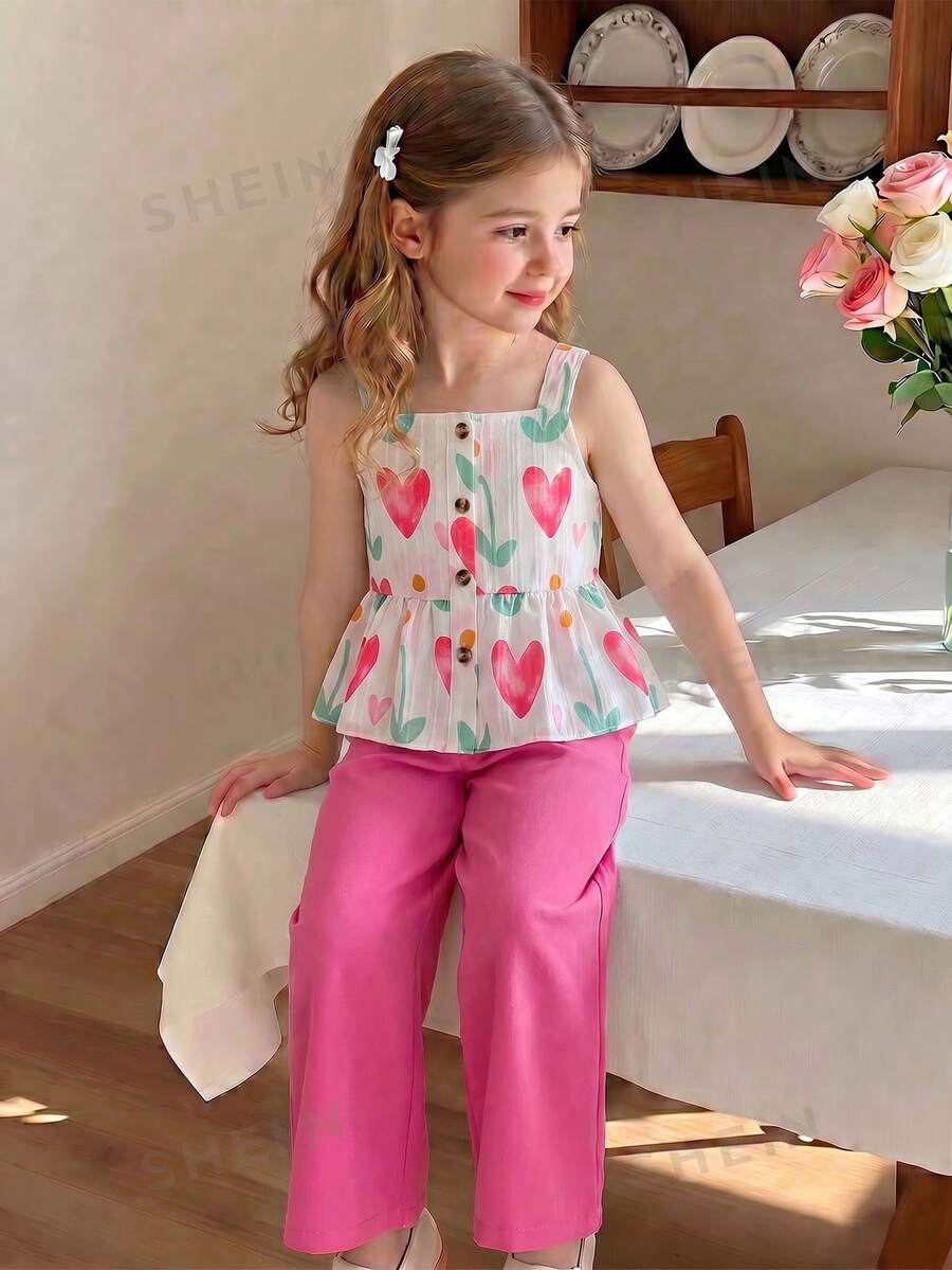 SHEIN Elladie kids 春夏季女童兩件式套裝，心形與花卉印花方領吊帶上衣 + 桃紅色寬腿長褲，方領吊帶設計適合夏季，胸前鈕扣細節增添優雅，荷葉邊下擺剪裁俏皮活潑；清新心形與花卉印花充滿活力可愛，搭配純色長褲打造簡約優雅造型，整體風格甜美亮眼，適合日常出遊、遊樂園、派對、親子活動等