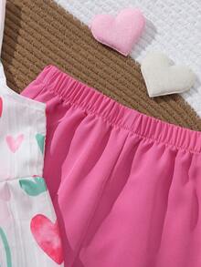 SHEIN Elladie kids 春夏季女童兩件式套裝，心形與花卉印花方領吊帶上衣 + 桃紅色寬腿長褲，方領吊帶設計適合夏季，胸前鈕扣細節增添優雅，荷葉邊下擺剪裁俏皮活潑；清新心形與花卉印花充滿活力可愛，搭配純色長褲打造簡約優雅造型，整體風格甜美亮眼，適合日常出遊、遊樂園、派對、親子活動等 - 粉色 - 查看 6