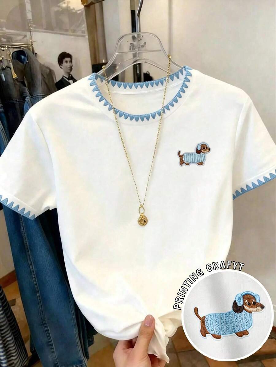 少女白色底蓝色三角边饰腊肠犬刺绣短袖T恤 - 纯白色底,领口和袖口饰有清新的蓝色三角锯齿边,左胸绣有可爱的腊肠犬图案,狗狗穿着浅蓝色针织衫,俏皮又治愈,融合了清新少女风和趣味细节,适合日常外出、校园穿着以及与朋友的休闲聚会,是一款集可爱刺绣、清新边饰和舒适穿着体验于一体的时尚单品! - 彩色 - 查看 1