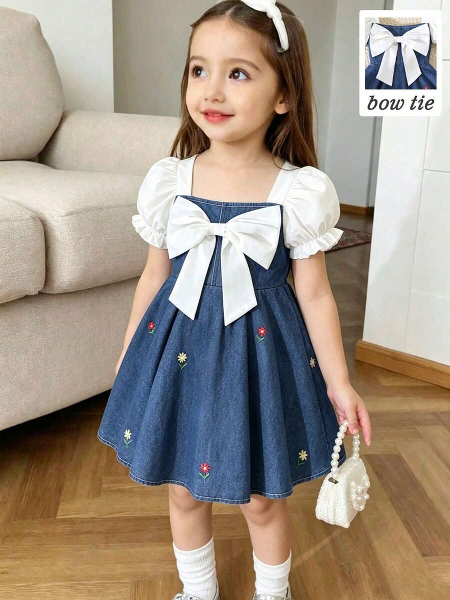 SHEIN Genkimix Kids 少女春夏新款方领泡泡袖蓝色数码印花连衣裙。可爱甜美的泡泡袖短袖搭配柔软的梭织面料，超大白色3D蝴蝶结点缀整体造型，精致的刺绣花卉数码印花图案勾勒出腰部线条，活泼动感。A字喇叭裙摆打造灵动身姿，非常适合旋转跳舞，适合生日派对、家庭出游、日常上学、度假、夏季穿着，展现可爱少女魅力，韩式简约舒适通勤风。