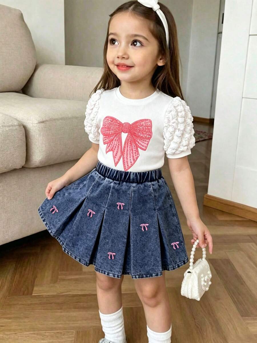 Elladie kids 两件套女童春夏套装，白色短袖上衣+牛仔裙；泡泡袖设计，袖口饰有荷叶边，胸前印有粉色蝴蝶结，百褶裙也饰有粉色蝴蝶结，甜美可爱风格，适合日常外出和亲子活动