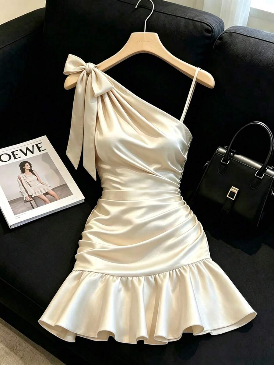 SHEIN Franclia 香檳色緞面洋裝,柔和光澤質感,不對稱肩部蝴蝶結設計,細緻側邊肩帶,收腰褶皺修飾身形,荷葉邊裙襬,貼身剪裁,優雅微性感,約會與派對完美之選 - 米色 - 查看 1