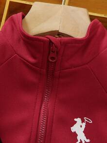 SHEIN 幼童兒童2件組POLO短袖上衣套裝，兒童服飾套裝，整體淺米色，休閒風格，半拉鍊高領設計，側面黑色條紋裝飾，附贈配套斜背小包，包包與衣服均有黑馬圖案，下身為慢跑長褲，側面同樣有黑色條紋，整體簡約時尚，適合日常穿著 - 酒紅色 - 查看 8