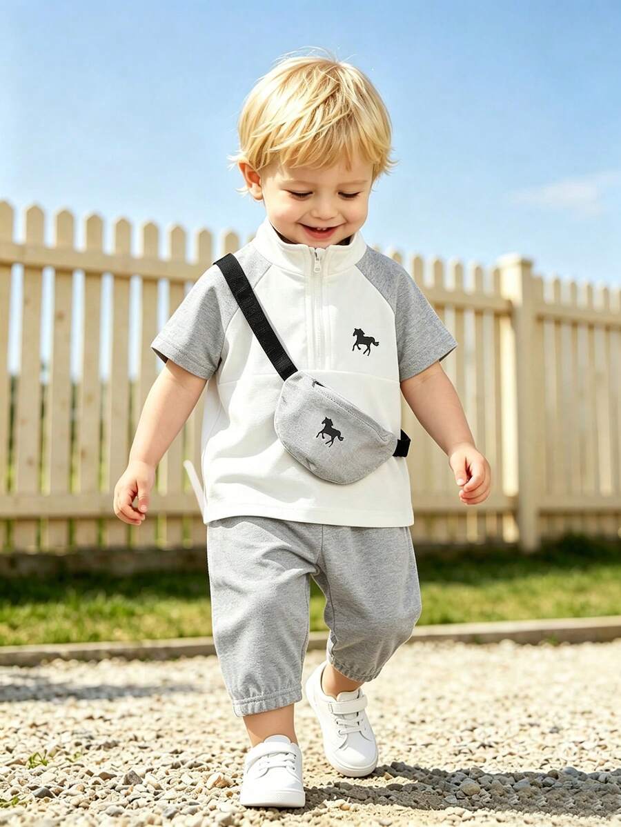 SHEIN 幼童兒童POLO衫短袖2件套,這是一套兒童服裝,整體淺米色,休閒風格,高領半拉鍊,兩側有黑色條紋裝飾,還附帶一個配套的斜挎小包,包包和衣服都有黑馬圖案。下身是慢跑褲,兩側同樣有黑色條紋,整套簡單時尚,適合日常穿著。 - 灰色 - 查看 1