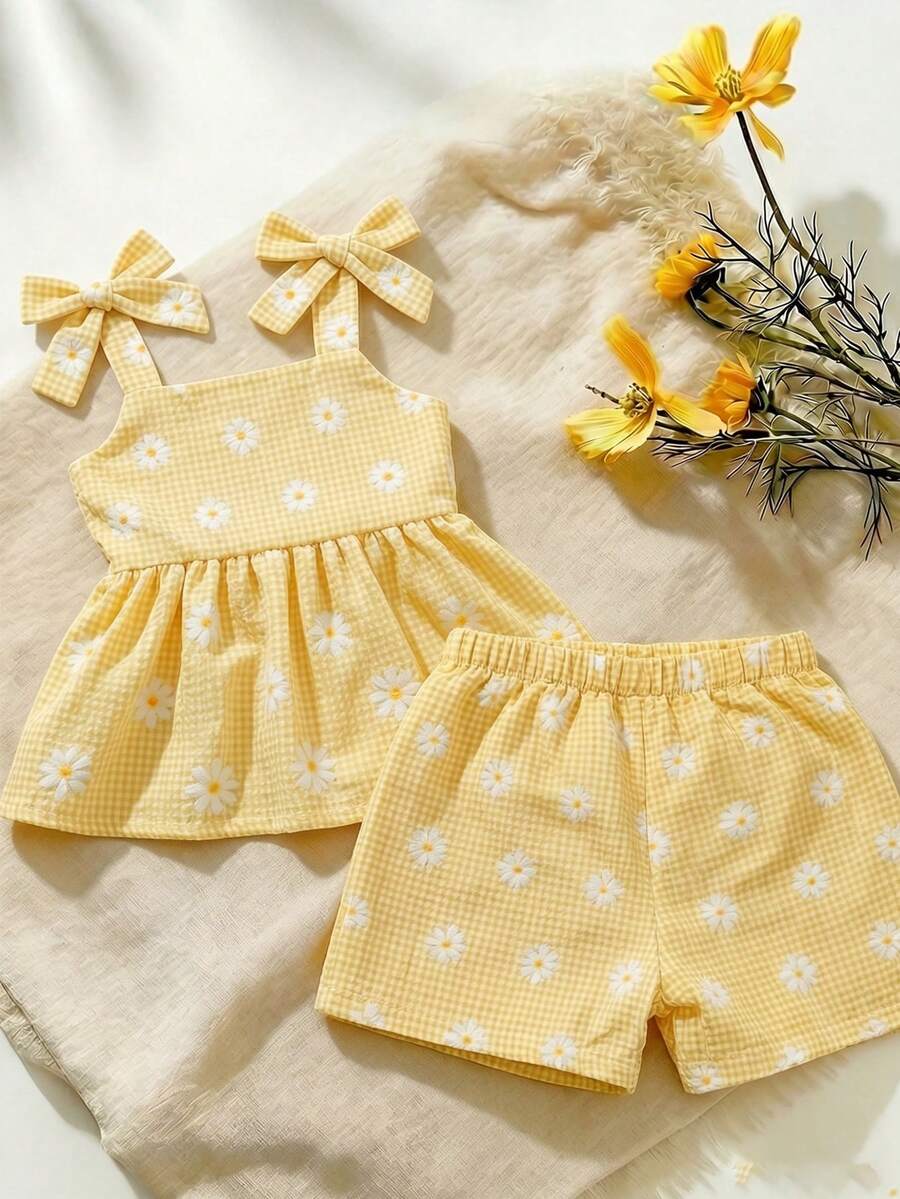 SHEIN Vintaside Kids 这款少女风两件套，包括一件黄色吊带上衣和一条带口袋的高腰牛仔短裤，甜美可爱又百搭，是春夏的理想之选。梭织面料厚度适中，饰有荷叶边蝴蝶结和立体花朵，豹纹纽扣更添复古气息。适合日常上学、游览热门景点、度假旅行、居家休闲以及参加派对等各种场合。 - 黃色 - 查看 1