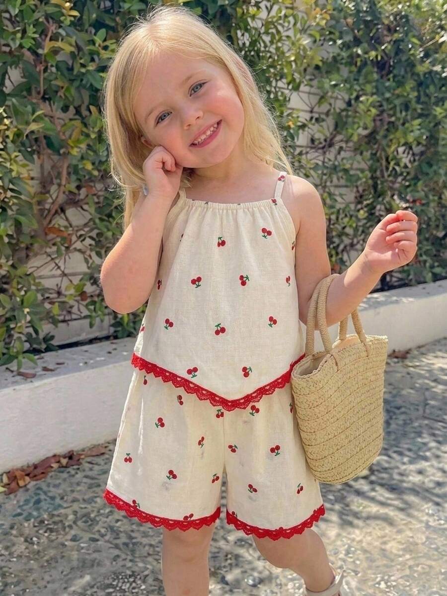 Elladie kids 2件組少女套裝，乳白色底色搭配櫻桃印花與蕾絲飾邊，清新且鮮豔的配色適合少女，短吊帶設計搭配紅色蕾絲邊緣呼應整體櫻桃主題，增添甜美細節，柔軟可愛的夏季女孩風格，櫻桃+紅白配色
