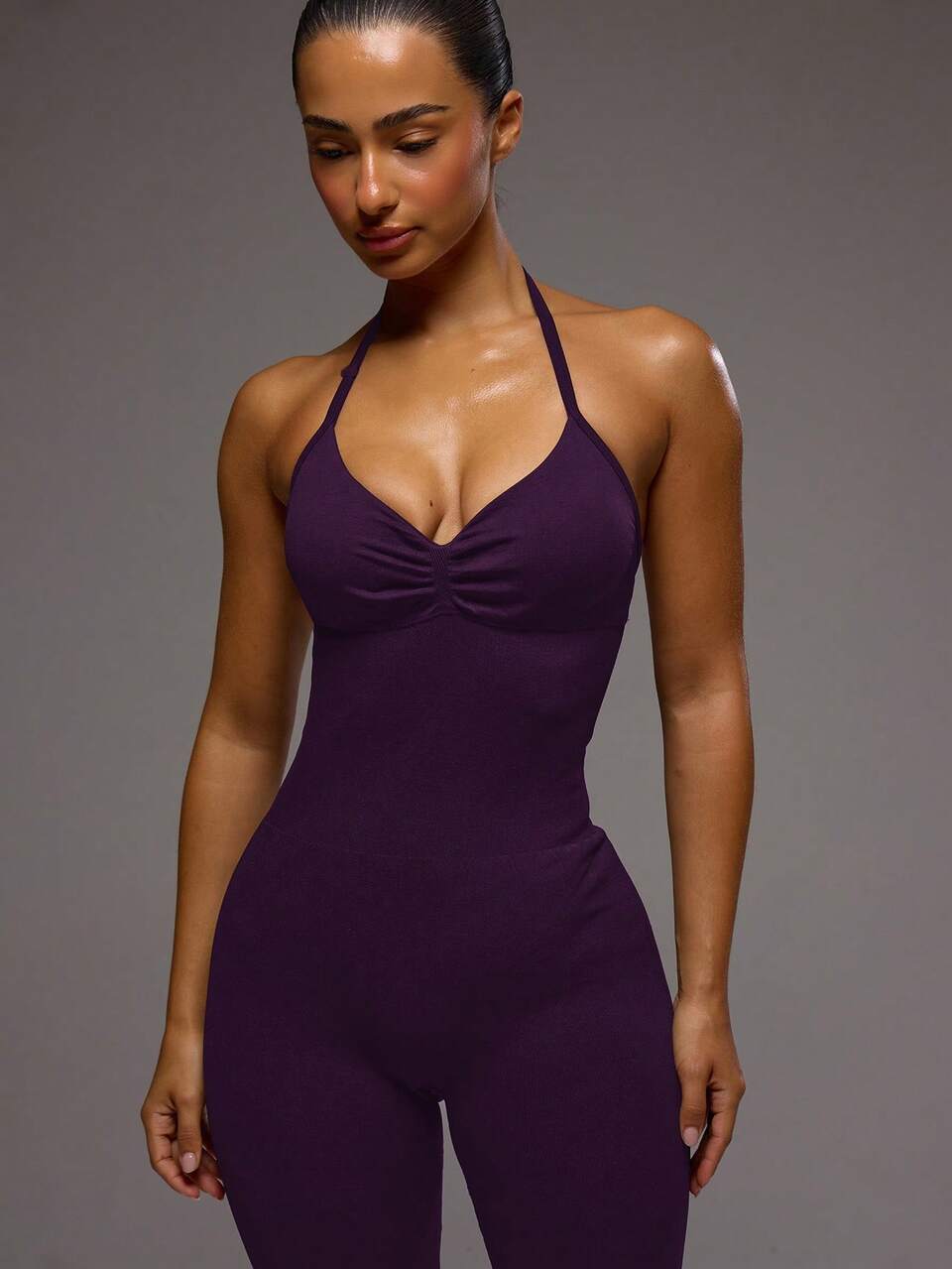 Mono deportivo morado oscuro con detalles fruncidos, acolchado y cuello halter