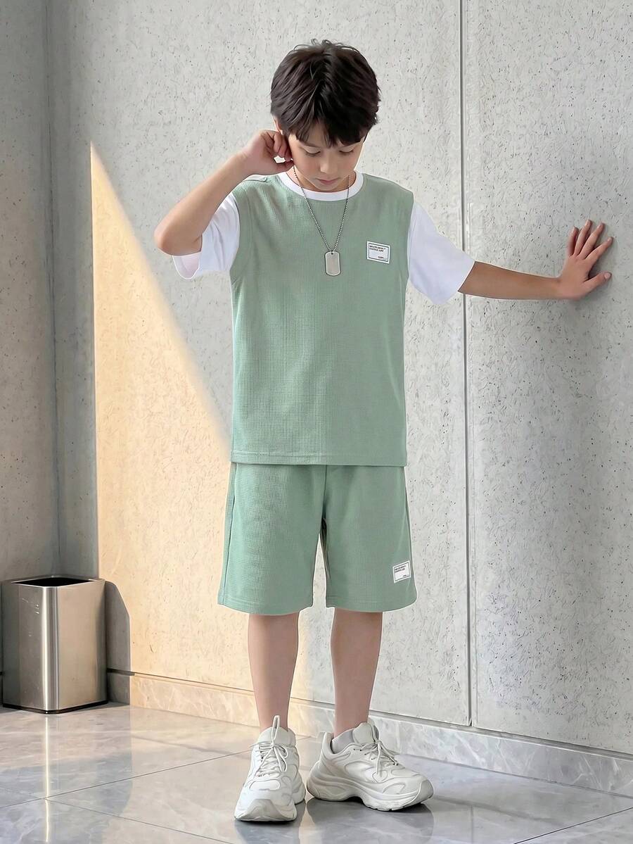 SHEIN Casuvi Kids 夏季男童两件套,上衣为浅绿色纹理针织圆领短袖T恤,搭配白色针织撞色袖子,正面饰有撞色标语贴片;下装为撞色条纹运动短裤,同样饰有标语贴片。这套运动休闲套装适合日常穿着、度假、运动、上学、参加节日活动。 - 綠色 - 查看 1