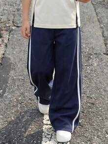 Casuvi Kids 宽松版型藏蓝色休闲运动裤，适合青少年男孩穿着，两侧有两条白色条纹，“CALIFORNIA”字样和椭圆形“CAx”标志图案，适合上学、运动和休闲周末穿着。 - 藏蓝色 - 查看 1