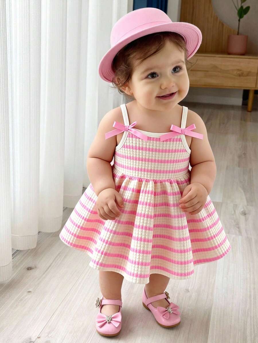 SHEIN Playful Pals Robe trapèze à bretelles spaghetti pour bébé fille. Cette robe présente un design à bretelles spaghetti, simple et élégant. La jupe trapèze met en valeur un style vif et mignon. La coupe ample de cette robe convient aux bébés de tous les types de corps. Elle est non seulement parfaite pour les vacances à la plage, les pique-niques en plein air et autres sorties d'été, mais aussi pour un port décontracté, permettant aux bébés de montrer leur charme unique tout en profitant d'un moment détendu et confortable. - Rose bonbon - Voir 1