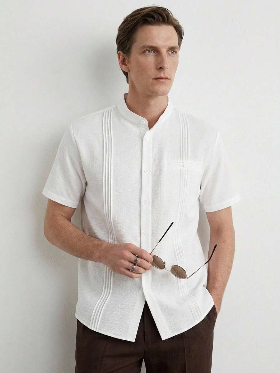 Manfinity CityGents 男士白色纹理立领短袖衬衫,侧边褶裥装饰,带小翻盖口袋,休闲款;男士瓜亚贝拉风格立领短袖白色衬衫,褶裥细节,适合夏季休闲穿着;立领纹理面料休闲上衣;2026春夏白色褶裥休闲衬衫 - 白色 - 查看 1