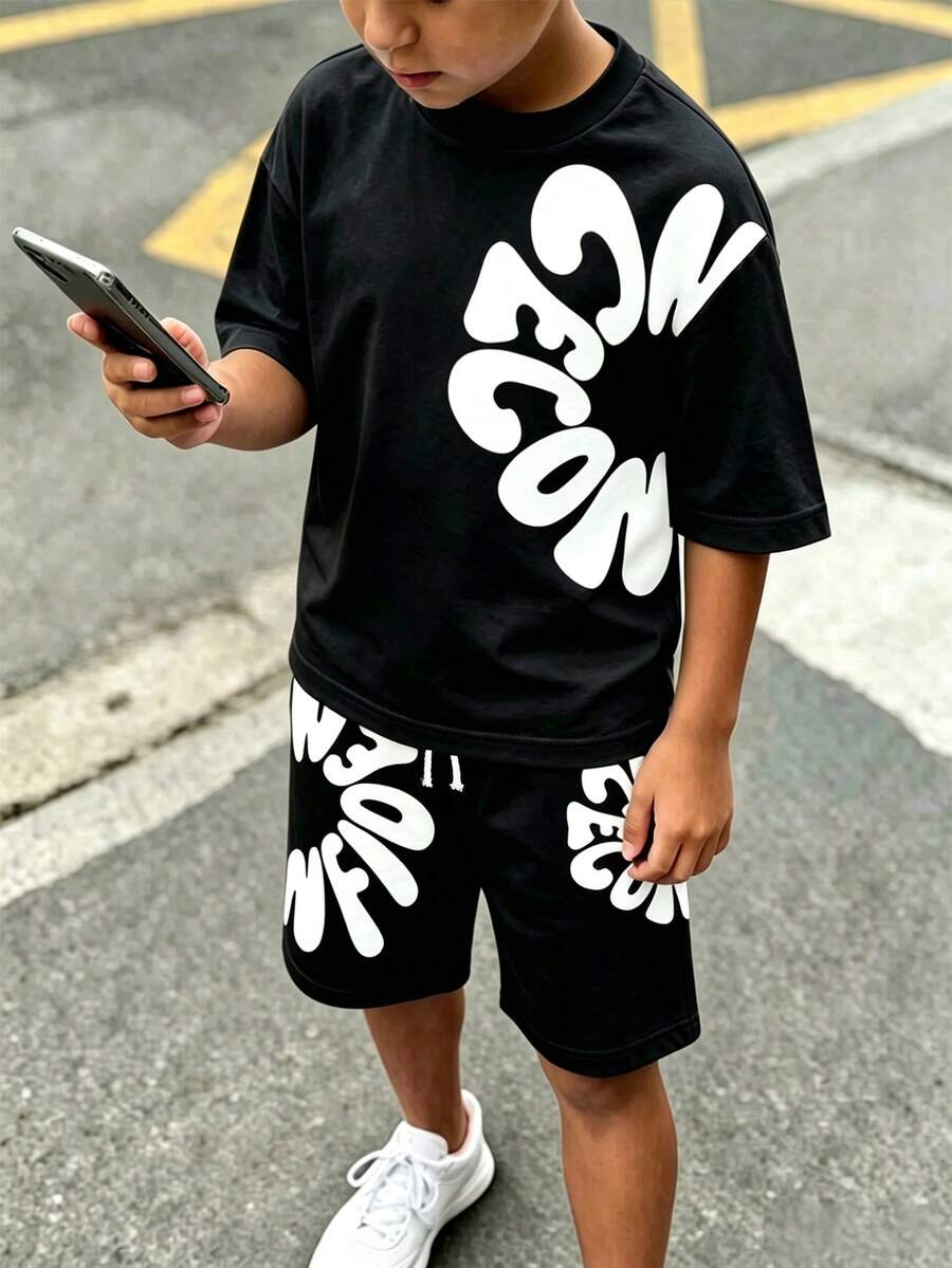 SHEIN 男童 T 恤套裝 2 件組,夏季時尚酷感卡通不對稱字母印花短袖圓領 T 恤,搭配同款印花鬆緊腰抽繩裝飾短褲,柔軟彈性面料,寬鬆版型,春夏時尚男童 T 恤套裝,休閒舒適百搭,適合外出與街頭風 - 黑色 - 查看 1