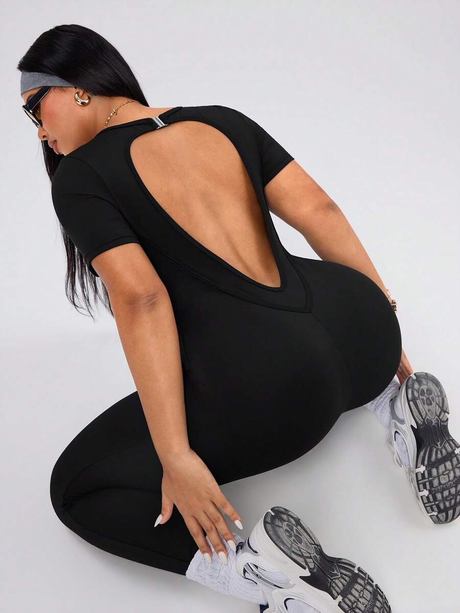SHEIN Rhythm Era Spring Summer Plus Size Women's Sports Jumpsuit, Round Neck Short Sleeve, Front Split Seam, Back Cutout With Buckle, 9/10 Length, Black, Slim Fit - Black - View 1