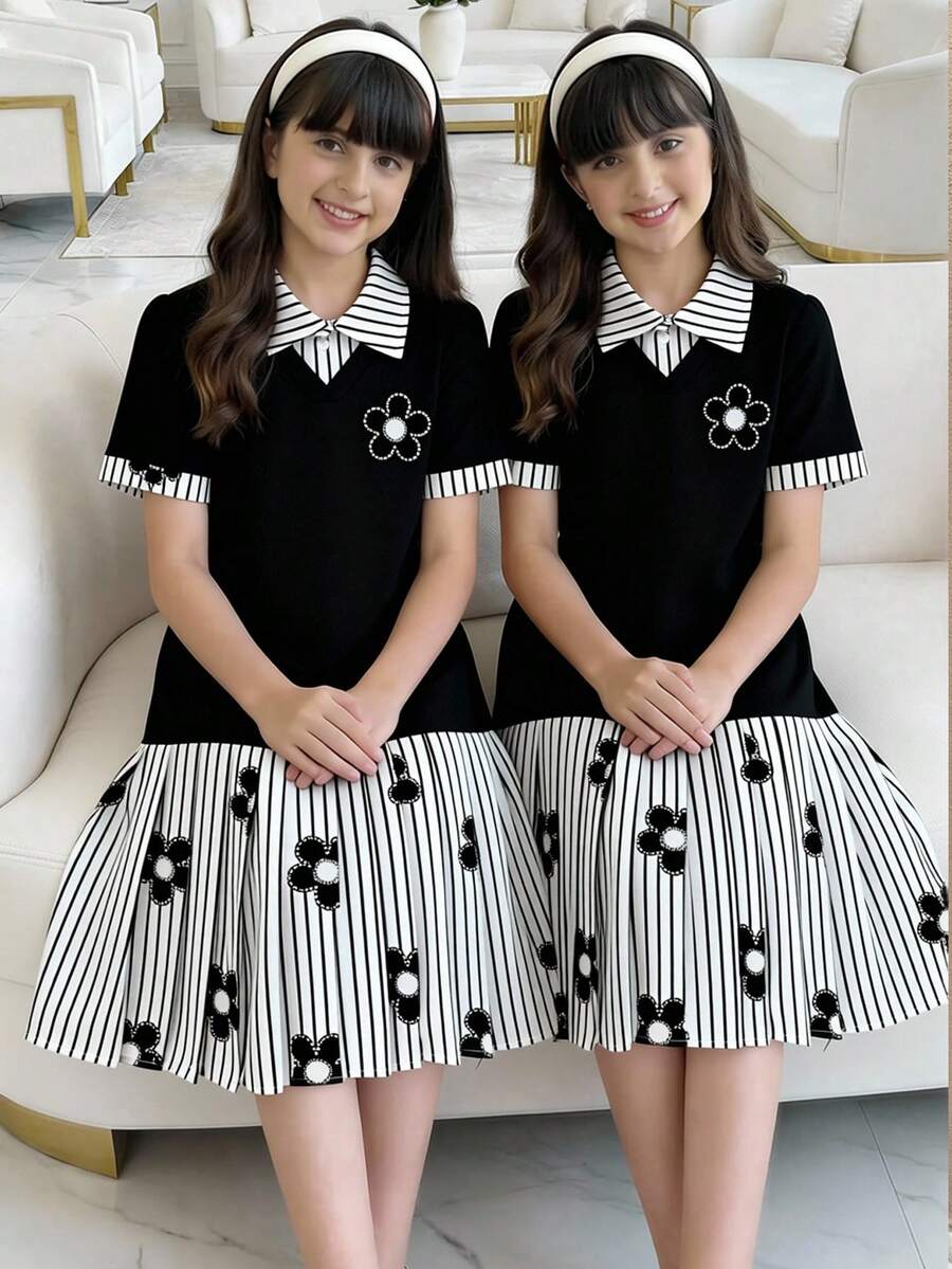 一件女童学院风拼接连衣裙,黑色针织上衣为主体,搭配黑白条纹印花领口和袖口,领口处的黑色花朵装饰增添俏皮感,下半部分为条纹百褶裙,与上衣相呼应,整体风格清新青春,适合日常通勤或休闲外出穿着。 - 黑色 - 查看 1