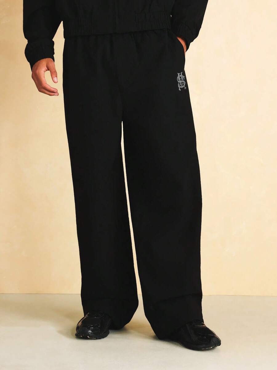 SUMWON Wide Leg Nylon Textured Jogger Pants With Monogram Embroidery Logo Detail And Elastic Waistband - Black - View 1