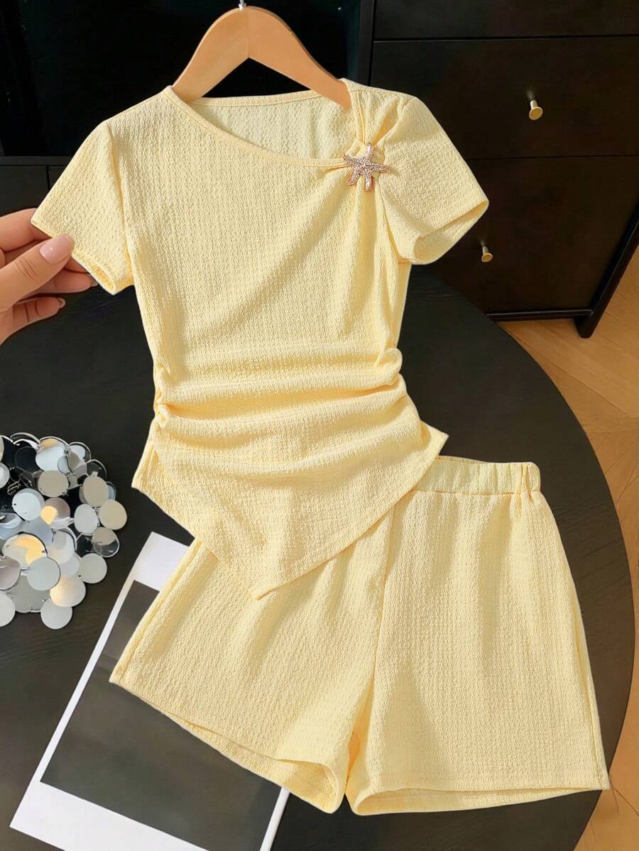SHEIN Set Mini 2pcs/Set untuk Anak Perempuan Remaja, Lengan Pendek, Leher Bulat, Warna Kuning, Desain Tekstur, Hem Asimetris, Dekorasi Bintang Laut, Kaos dan Celana Pendek, Musim Panas