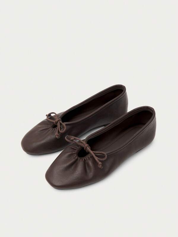 Nöista Tiefbraune Ballerinas mit Lederoptik, weiche runde Zehenpartie und zartes Schleifendetail, erzeugen einen zeitlosen und minimalistischen Stil.