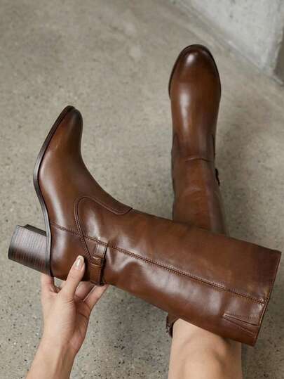 Bota alta de mujer en piel sintética color café, tacón medio ancho, detalle de hebilla lateral, estilo elegante y clásico, calzado cómodo para looks formales, casuales