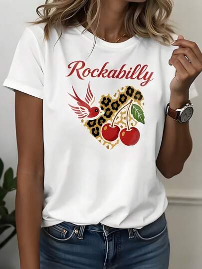 Camiseta de mujer con transfer "Rockabilly", letras rojas estilo retro, ave roja, cerezas dobles y corazón con estampado leopardo en tonos amarillo marrón y manchas negras.