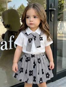 SHEIN Playful Pals 2 قطعة/مجموعة بلوزة بيضاء بأكمام قصيرة وطبعة زهور لطيفة بتصميم بسيط مع أزرار على الكتف وشال + تنورة مطوية بطبعة زهور مخططة باللونين الأسود والأبيض مع خصر مطاطي، ملابس كاجوال بأسلوب كوري أنيق وعصري، مناسبة للارتداء اليومي في الصيف والسفر والعطلات والحدائق والمنتزهات الترفيهية والحفلات والمناسبات الأخرى - أبيض وأسود - مشاهدة 11