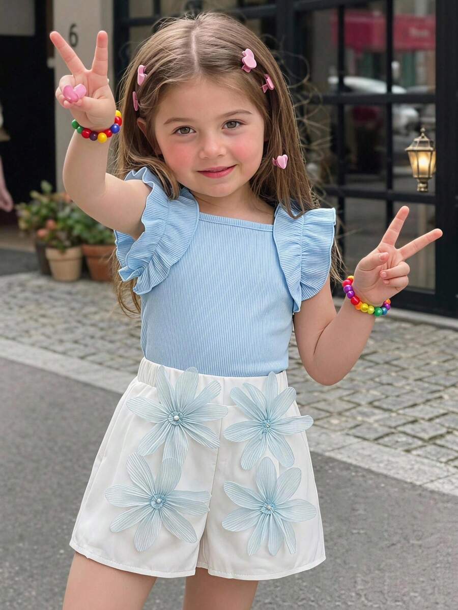 Elladie kids 这款两件套童装甜美俏皮风套装，包含一件无袖褶皱背心和一件针织腋下条纹T恤上衣，搭配粉色松紧腰短裤，饰有精致立体定位白色花朵，可爱时尚，适合夏季日常穿着。