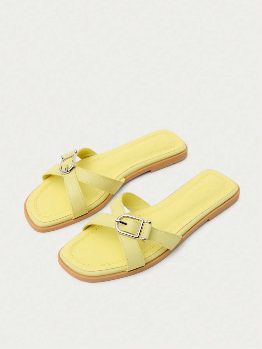 Nöista Sandalia plana minimalista con correas cruzadas, detalle de hebilla de metal pulido, punta cuadrada y plantilla acolchada en acabado amarillo suave. - Amarillo - Ver 1