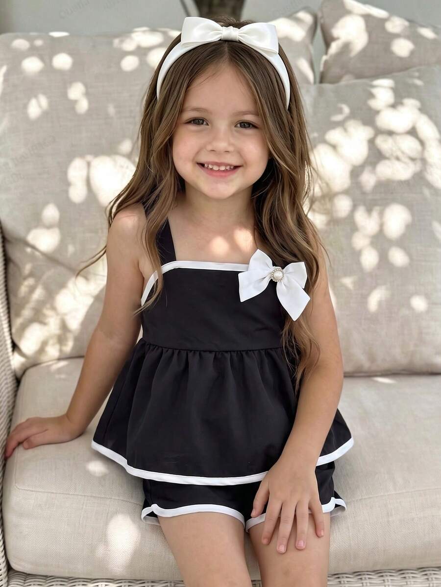 SHEIN Elladie kids 两件套女童黑白蝴蝶结吊带背心和短裤套装,优雅休闲风格,撞色滚边荷叶边下摆和珍珠点缀,采用柔软舒适的面料,适合春夏外出、派对和日常穿着。时尚百搭的两件套童装,适合小朋友。 - 黑色 - 查看 1