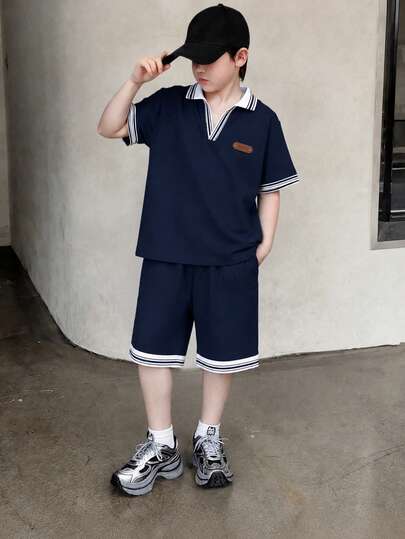 Bộ quần áo mùa hè cho bé trai tuổi teen màu be và xanh navy, phong cách tối giản thường ngày, họa tiết jacquard phối màu, áo tay ngắn và quần short, dáng rộng thoải mái, phù hợp đi chơi hàng ngày, hoạt động trường học, họp mặt gia đình và vui chơi ngoài trời