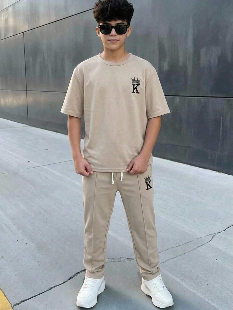 SHEIN 两件装青少年男童休闲运动学院风复古圆领卡其色T恤和长裤套装,饰有章节装饰,适合儿童穿着,幼儿男童服装,返校季男童套装,适合生日派对、晚宴、演出、婚礼、洗礼、开幕式等场合,日常穿着也适合上学、旅行、运动,适合春夏季节,母亲节/母女装。 - 彩色 - 查看 1