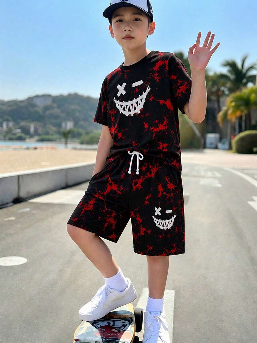 SHEIN 男童 T 恤套裝,深紅色與黑色潑墨紮染底色,搭配趣味「惡魔微笑」印花,上衣胸前與短褲均印有趣味惡魔微笑、X 型眼睛 + 鋸齒嘴設計,柔軟針織圓領短袖全印花套頭上衣,搭配鬆緊腰帶口袋針織短褲,男童服裝,男童套裝 - 黑色 - 查看 1