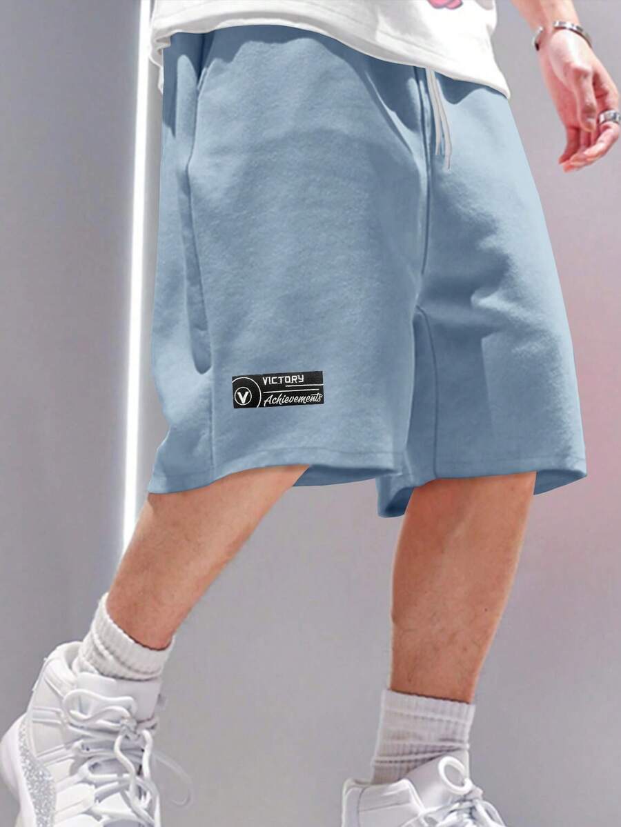 Manfinity Roghcode Pantalones cortos holgados de talla grande para hombres con estampado de letras, cintura con cordón y bolsillos en diagonal, adecuados para el uso diario y las vacaciones - Celeste - Ver 1