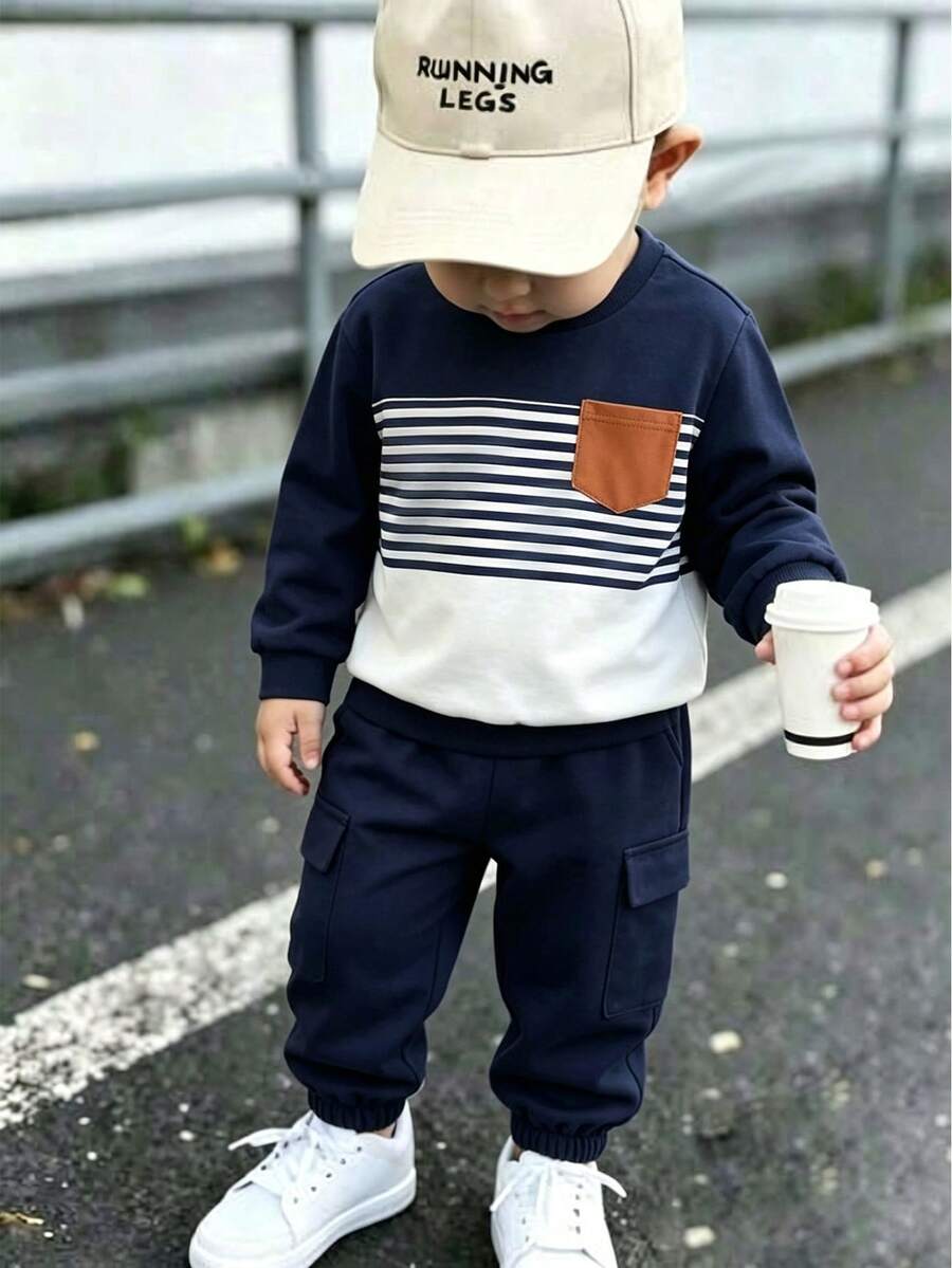 SHEIN Casuvi Kids 男童秋冬條紋長袖慢跑褲 2 件套，海軍藍分段條紋圓領上衣搭配焦糖色對比貼布口袋與同色系長褲，打造完美呼應的簡約清新日常休閒穿搭