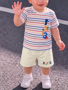 SHEIN Playful Pals 男童基础款圆领短袖T恤套装，白色底色，饰以彩色条纹图案，右侧印有卡通“1、2、3”字样，搭配同色系米色休闲短裤，短裤上也印有卡通图案，面料柔软清新，色彩鲜艳，款式可爱。 - 彩色 - 查看 4