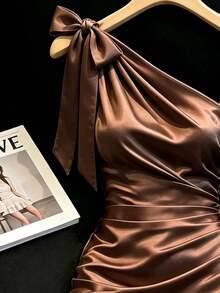 SHEIN Franclia 香檳色緞面洋裝，柔光質感與高級面料，不對稱單肩蝴蝶結設計，側帶層次細節，抓皺收腰修飾腹部，荷葉邊下擺展現俏皮優雅，修身剪裁凸顯曲線，適合約會、派對等多種場合，輕鬆成為目光焦點 - 咖啡棕 - 查看 4