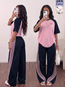 SHEIN Sparklyn 這套 T-Shirt 套裝採用粉色與綠色拼接設計，落肩短袖搭配蝴蝶結裝飾圖案 + 直筒寬腿褲，寬鬆休閒版型，甜酷混搭風格，適合日常出遊，搭配飾品更顯活力 - 藍色 - 查看 1