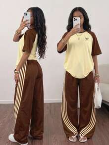 SHEIN Sparklyn 這套服裝包含一件粉色與綠色拼接的落肩短袖 T 恤，飾有蝴蝶結圖案 + 直筒寬腿褲，寬鬆休閒版型，甜酷混搭風格，適合日常穿著，搭配配件更顯活力 - 棕色 - 查看 1