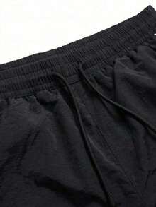 Manfinity Denimwave بنطال رياضي فضفاض للرجال من قماش النايلون سريع الجفاف مع خطوط جانبية متباينة وطباعة حروف وخصر برباط قابل للتعديل وحافة قابلة للتعديل بنمط جوجر واقٍ من الرياح بنمط الشارع - الأسود - مشاهدة 4