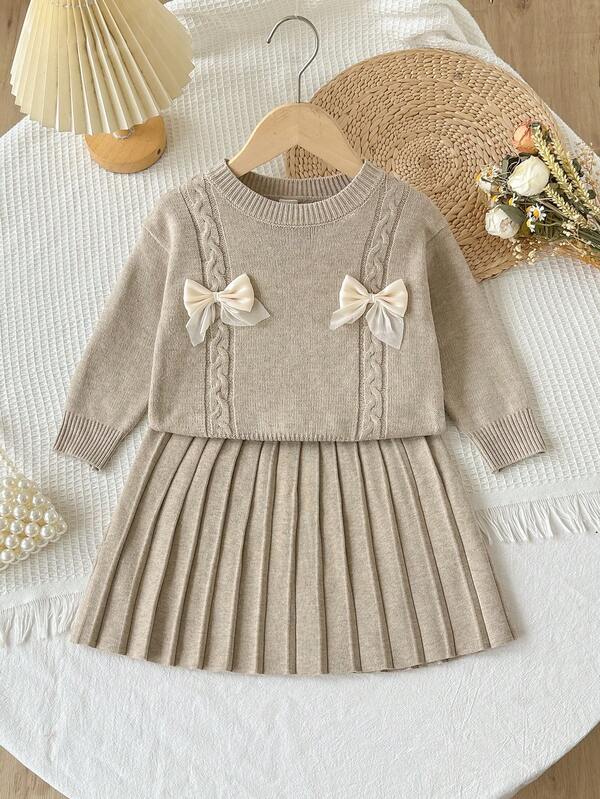 SHEIN Niñas (Pequeño) Suéter de punto de cable con cuello redondo, hombros caídos, manga larga y lazo de organza hecho a mano en color avena + Falda plisada a juego, suave y cómodo, adecuado para uso diario, salidas, viajes, vacaciones, hogar, guardería y juegos